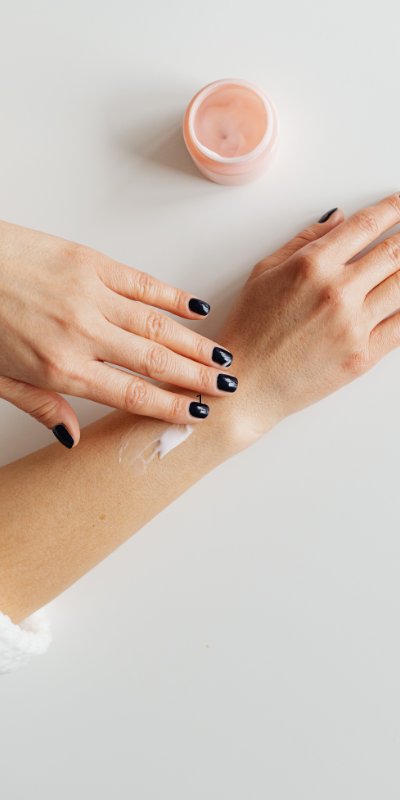 A woman rubbing cream on her arm that has eczema.